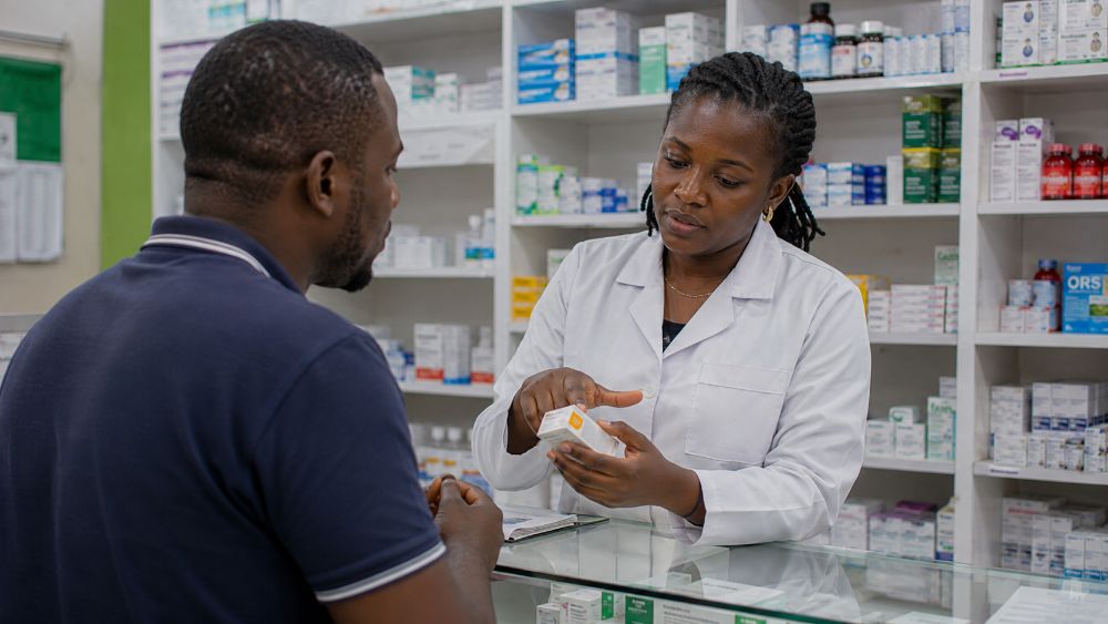 Pharmacist explaining medicine use to a customer